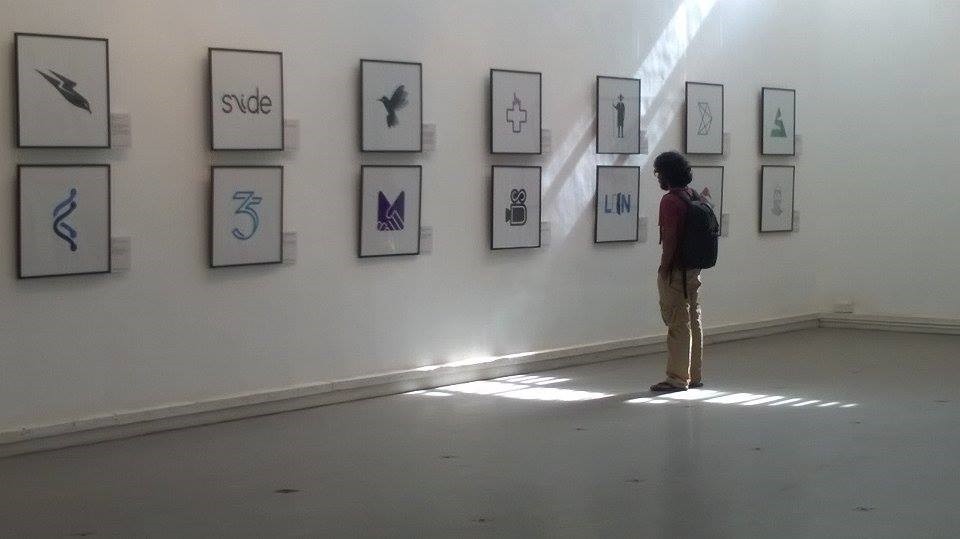 Visitor viewing a wall of logo prints at the SIMPLICITY exhibition