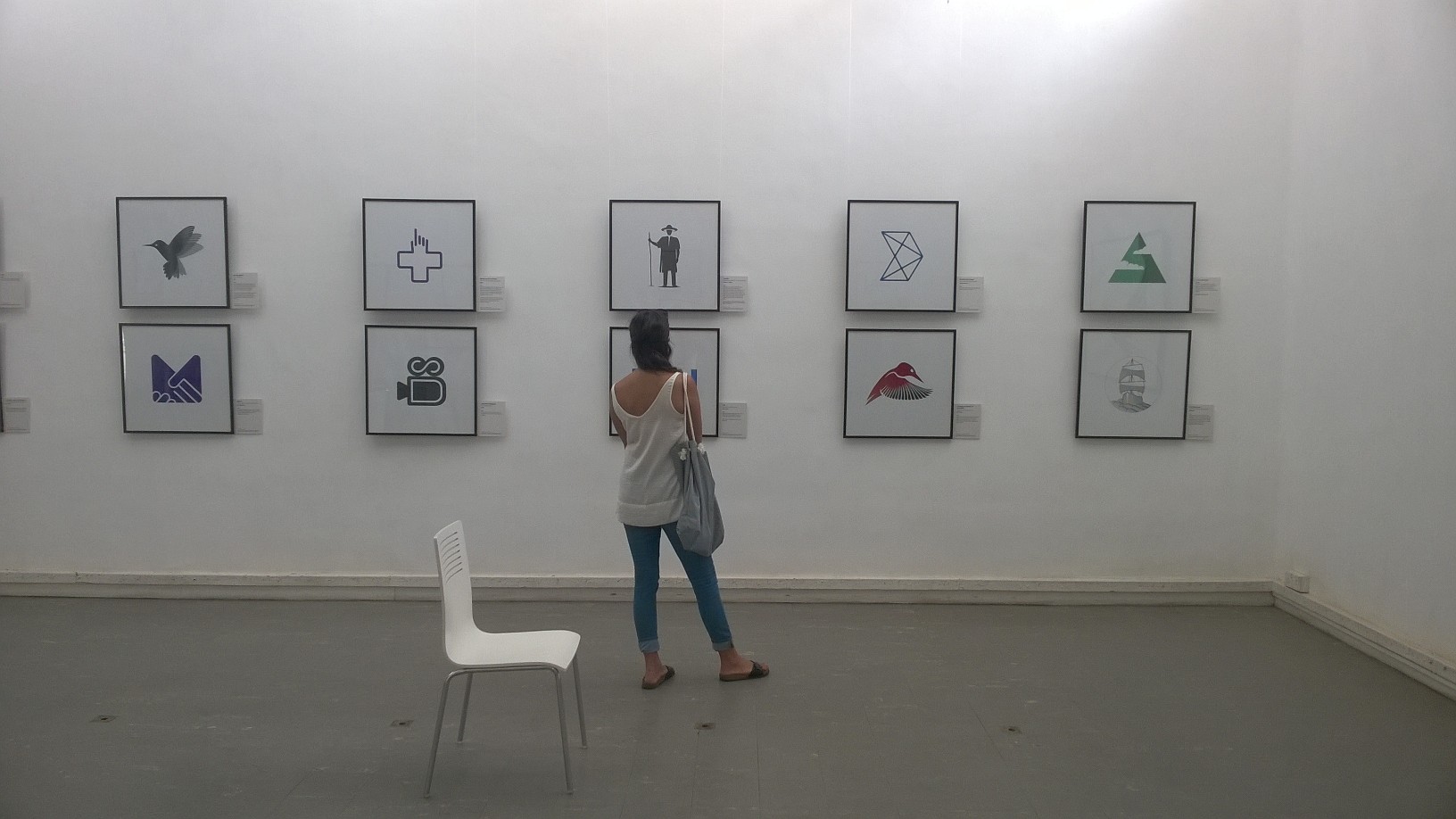 Visitor viewing framed bird and icon logo prints at the SIMPLICITY exhibition