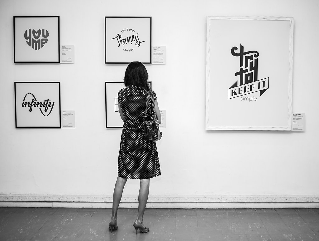 Visitor viewing framed logo prints at the SIMPLICITY exhibition